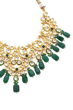 22k gold plated half crescent shaped pendant necklace with green kundan, stone embellishment and bead drops. Comes with earrings.
Components: 1 Necklace, Pair of earrings
Type: Kundan, Stone, Bead
Composition: Mixed Metal Alloy
Color: Green
Other Details: 
Dimensions L x B x H (in cm):
Necklace: 46 x 9.4 x 1
Earrings: 10 x 4.5 x 1
Weight (in gms): 300
Closure:
Necklace: Pull out drawcord
Earrings: Push back clasp - Aza Fashions Heavy Green Kundan Necklace For Eid, Green Chandbali Kundan Necklace For Eid, Green Chandbali Bridal Necklace For Eid, Eid Green Chandbali Kundan Necklace, Heavy Green Necklace For Eid, Festive Green Chandbali Necklace, Crescent Shape, Jewellery Sets, Green Jewelry