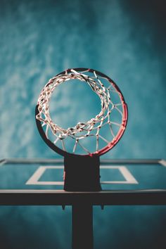 a basketball hoop that is on top of a table in front of a blue wall