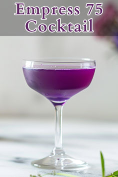 a purple cocktail in a coupe glass with the words empress'75 cocktail on it