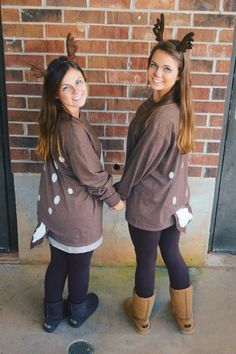 two young women standing next to each other in front of a brick wall wearing reindeer costumes