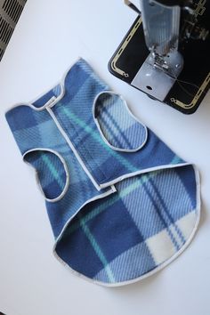 a blue plaid bib with a sewing machine next to it on a white table