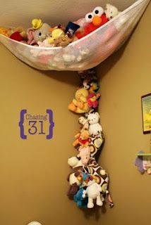 there are many stuffed animals hanging from the ceiling in this child's playroom