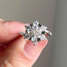 a person holding a diamond ring in their hand