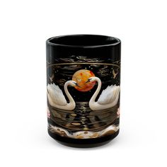 two white swans in the water with an orange ball on their head and one black mug