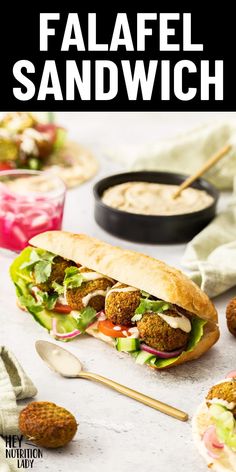 falafel sandwich with pita bread and salad in the middle, on a table