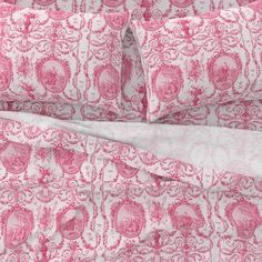 the pink and white bedding is made up with paisley designs on it's sheets