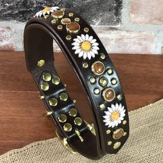 a black leather bracelet with sunflowers on it