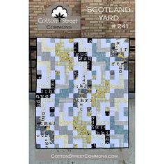 the cotton street yard quilt pattern is shown in front of a brick wall and it has a