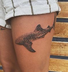 a woman's thigh with a tattoo of a fish on the bottom half of her leg