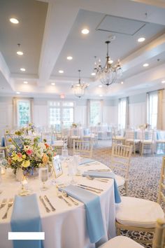 a banquet room set up with white linens and blue napkins