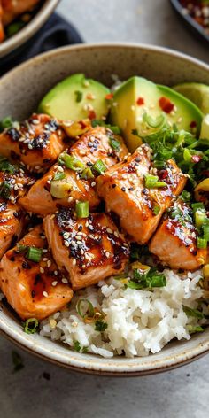 a bowl filled with rice and salmon on top of a table