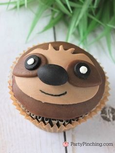 a cupcake with chocolate frosting decorated like a slotty face on top of it