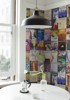 a white table in front of a large window with pictures on the wall behind it