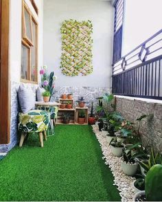 an outdoor patio with artificial grass and potted plants