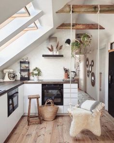 an attic kitchen with white walls and wooden floors