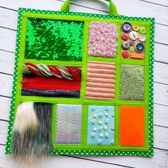 a green bag with buttons and other things on it