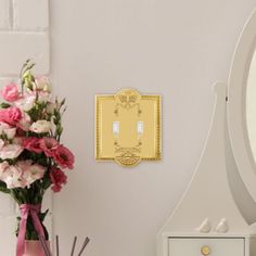 a vase filled with flowers next to a white dresser and mirror on top of a wooden table