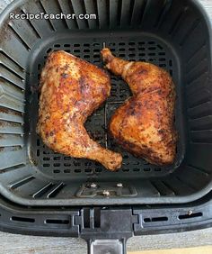 two pieces of chicken sitting in an air fryer