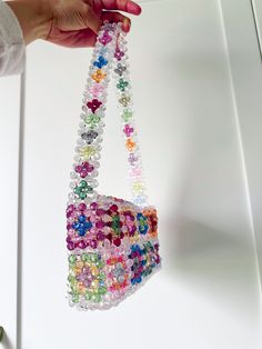 a hand holding a bag made out of beads