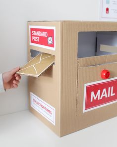 a person opening a mail box with a red post stamp on the front and bottom