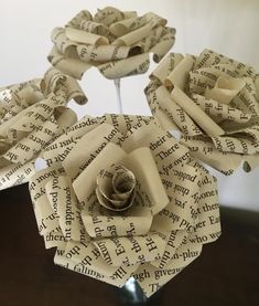 an origami rose made out of book pages sitting on top of a table