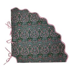 an ornately designed placemat with pink and green flowers on the edges, tied together