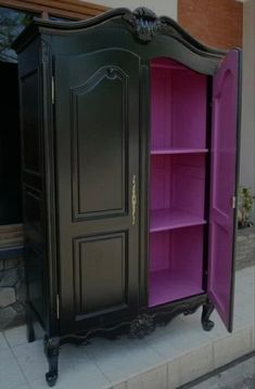 a black and pink armoire sitting on top of a sidewalk