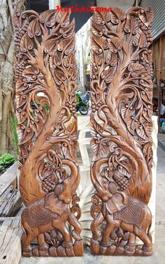 two carved wooden doors with an elephant and tree design on the front, one is made out of wood