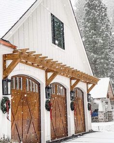 a white building with wooden doors and windows covered in snow