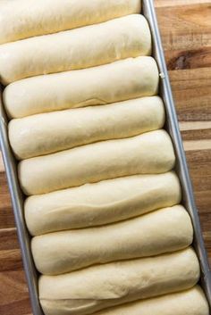 a pan filled with dough sitting on top of a wooden table