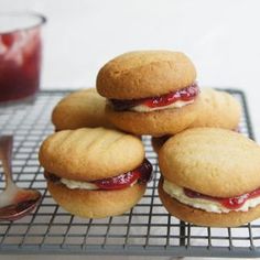 four cookies with jelly and cream filling on a cooling rack