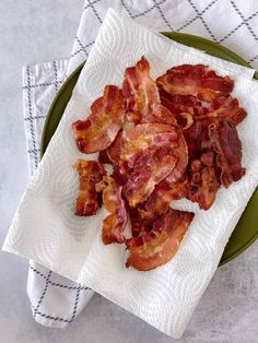 bacon on a napkin sitting on top of a green plate