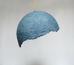 a blue piece of art hanging from a string