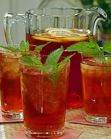 three glasses filled with iced tea sit on a table