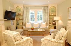 a living room filled with furniture and a flat screen tv mounted on the wall above a fireplace