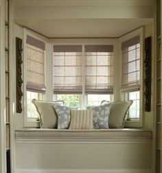 a window seat with pillows on top of it