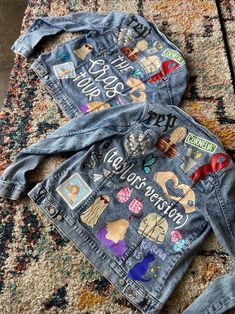 two jean jackets with patches on them sitting on a rug