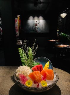 a bowl filled with sushi on top of a table next to a potted plant