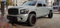 a silver truck is parked on the street