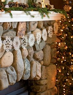 a fireplace decorated for christmas with snowflakes and pine cones