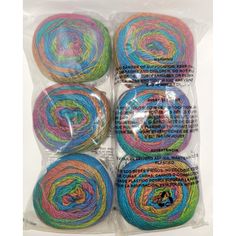 four balls of multicolored yarn in plastic packaging