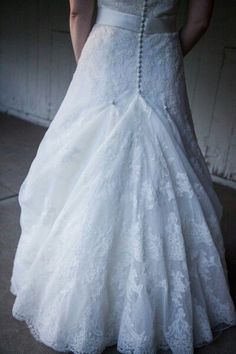 a woman in a white wedding dress is standing