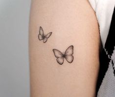 two butterflies tattoo on the arm