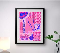 a pink and blue art piece hanging on the wall next to a white table lamp