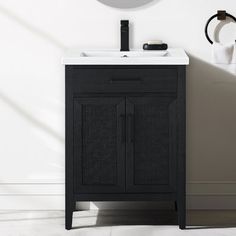 a white sink sitting under a mirror next to a black cabinet