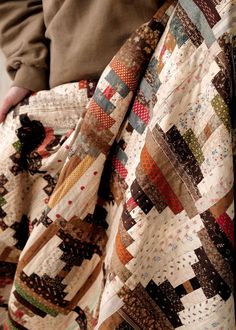 a person holding a quilt in their hands