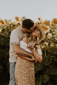 a man and woman hugging in front of a sunflower field