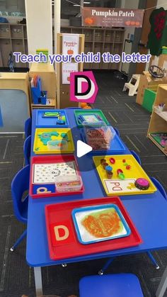 there is a blue table with colorful trays on it and the words teach your child the letter d