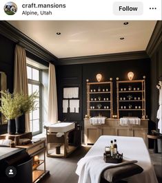 a spa room with black walls and white towels on the bed, two sinks in the middle