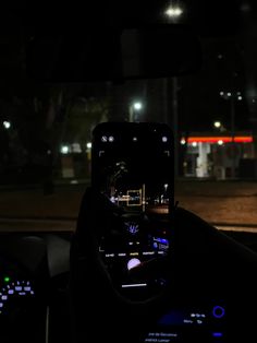 a person in a car driving at night with their cell phone up to the camera